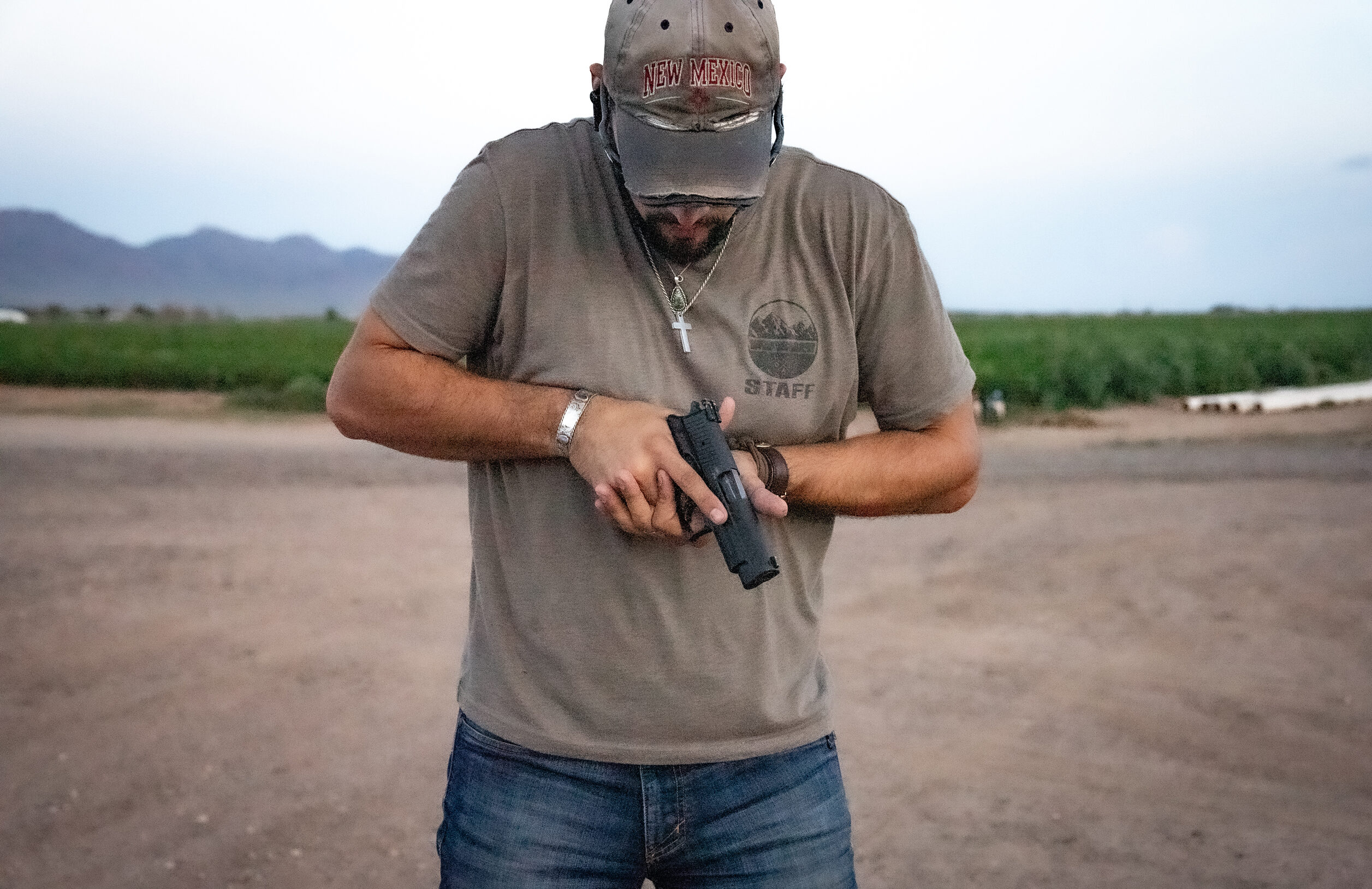 Man holding a pistol pointed at the ground.