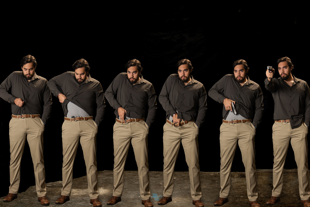 Man drawing a gun from a tucked shirt Drawing a gun from a tucked shirt