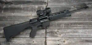 An AR-15 first rifle displayed on a wood background