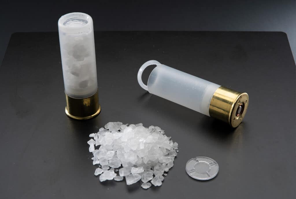 A rock salt shotgun shell cut open and displayed on a table